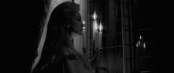 Movie still from “The Innocents” (1961), directed by Jack Clayton – A woman standing in front of a window holding a candle; Close Up shot, Over the shoulder angle
