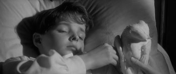 Movie still from “The Innocents” (1961), directed by Jack Clayton – A young boy is sleeping in a bed; Close Up shot, High angle