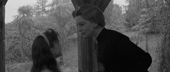 Movie still from “The Innocents” (1961), directed by Jack Clayton – A woman talking to a young girl in the rain; Close Up shot, Over the shoulder angle
