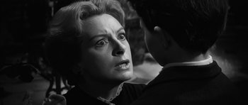Movie still from “The Innocents” (1961), directed by Jack Clayton – An older woman looking at a young man; Close Up shot, Over the shoulder angle