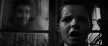 Movie still from “The Innocents” (1961), directed by Jack Clayton – A young woman with a face covered in rain drops; Close Up shot, Low angle