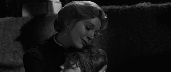 Movie still from “The Innocents” (1961), directed by Jack Clayton – A woman holding a child in her arms; Close Up shot, Low angle