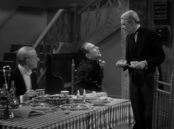 Movie still from “The Invisible Man Returns” (1940), directed by Joe May – Three men sitting at a table with food on it; Medium shot, High angle