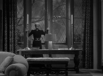 Movie still from “The Invisible Man Returns” (1940), directed by Joe May – A woman standing in front of an open window; Wide shot, High angle