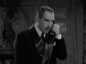 Movie still from “The Invisible Man Returns” (1940), directed by Joe May – A black and white photo of a man talking on a phone; Close Up shot, High angle