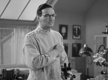 Movie still from “The Invisible Man Returns” (1940), directed by Joe May – A man standing in front of a camera in a room; Medium shot, Low angle