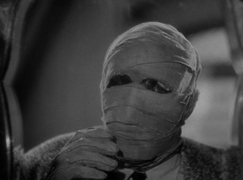 Movie still from “The Invisible Man Returns” (1940), directed by Joe May – A man in a suit and tie wrapped in gauze; Close Up shot, Low angle
