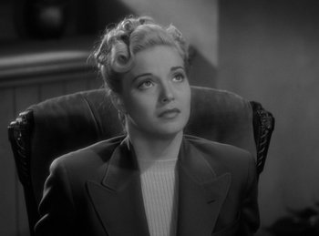 Movie still from “The Invisible Man Returns” (1940), directed by Joe May – A black and white photo of a woman in a suit; Close Up shot, High angle