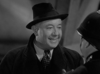 Movie still from “The Invisible Man Returns” (1940), directed by Joe May – An older man wearing a hat and a suit; Close Up shot, Over the shoulder angle
