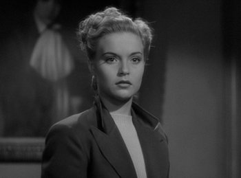 Movie still from “The Invisible Man Returns” (1940), directed by Joe May – A black and white photo of a woman in a suit; Close Up shot, Low angle