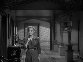 Movie still from “The Invisible Man Returns” (1940), directed by Joe May – A black and white photo of a woman standing in a room; Medium shot, High angle
