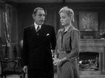 Movie still from “The Invisible Man Returns” (1940), directed by Joe May – A man and a woman standing next to each other in front of a fireplace; Medium shot, Low angle