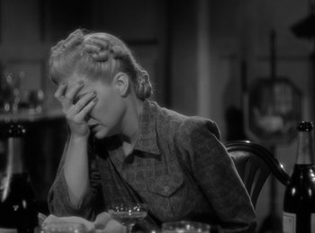 Movie still from “The Invisible Man Returns” (1940), directed by Joe May – A woman sitting at a table with her hand on her face; Close Up shot, High angle