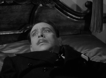 Movie still from “The Invisible Man Returns” (1940), directed by Joe May – A black and white photo of a man laying on a bed; Close Up shot, High angle