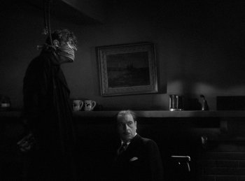 Movie still from “The Invisible Man Returns” (1940), directed by Joe May – A man in a suit and tie next to another man in a suit and tie; Medium shot, Low angle