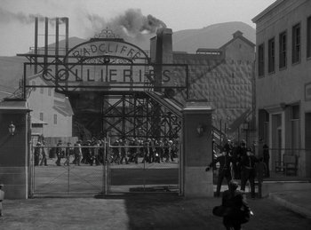 Movie still from “The Invisible Man Returns” (1940), directed by Joe May – A black - and - white photo of people walking on a street; Extreme Wide shot, High angle
