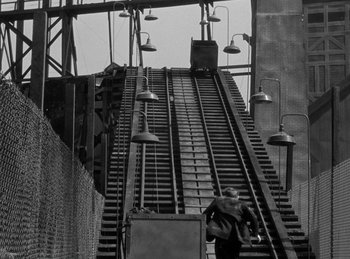 Movie still from “The Invisible Man Returns” (1940), directed by Joe May – A man is walking down a train track; Extreme Wide shot, High angle