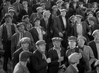 Movie still from “The Invisible Man Returns” (1940), directed by Joe May – A group of men in suits and hats standing in a crowd; Medium shot, High angle