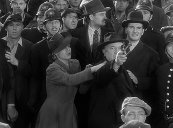 Movie still from “The Invisible Man Returns” (1940), directed by Joe May – A group of men and women wearing hats and holding guns; Medium shot, High angle