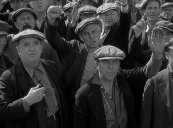 Movie still from “The Invisible Man Returns” (1940), directed by Joe May – A black and white photo of a group of men wearing hats; Medium shot, High angle