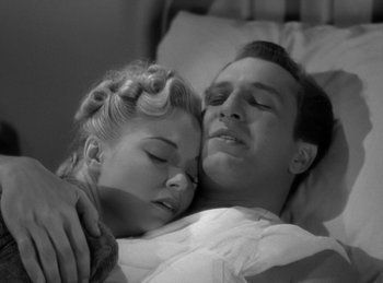 Movie still from “The Invisible Man Returns” (1940), directed by Joe May – A man and a woman laying in a bed together; Close Up shot, High angle