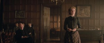 Movie still from “The Invisible Woman” (2013), directed by Ralph Fiennes – A woman in a black and white dress holding a white object; Medium shot, Low angle