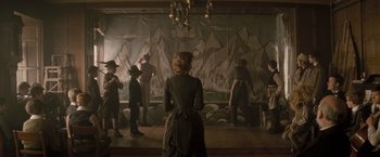 Movie still from “The Invisible Woman” (2013), directed by Ralph Fiennes – A group of people standing in front of a painting; Wide shot, High angle