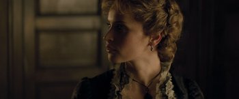 Movie still from “The Invisible Woman” (2013), directed by Ralph Fiennes – A woman in a black and white dress looking to her left; Close Up shot, Over the shoulder angle