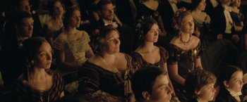 Movie still from “The Invisible Woman” (2013), directed by Ralph Fiennes – A group of people sitting in a room; Medium shot, High angle