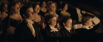 Movie still from “The Invisible Woman” (2013), directed by Ralph Fiennes – A group of people sitting in a room; Medium shot, High angle