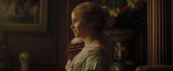 Movie still from “The Invisible Woman” (2013), directed by Ralph Fiennes – A woman in a green dress looking to the side; Close Up shot, Over the shoulder angle