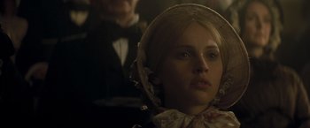 Movie still from “The Invisible Woman” (2013), directed by Ralph Fiennes – A young woman wearing a head scarf in a dimly - lit room; Close Up shot, Low angle