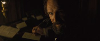 Movie still from “The Invisible Woman” (2013), directed by Ralph Fiennes – A man with a beard is looking at the camera; Close Up shot, Low angle