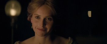 Movie still from “The Invisible Woman” (2013), directed by Ralph Fiennes – A person smiling for the camera; Close Up shot, Over the shoulder angle