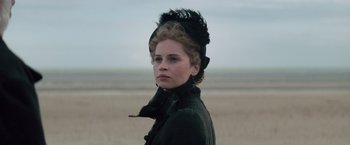 Movie still from “The Invisible Woman” (2013), directed by Ralph Fiennes – A woman in a black coat and a black hat; Close Up shot, Low angle