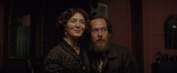 Movie still from “The Invisible Woman” (2013), directed by Ralph Fiennes – An older woman standing next to an older man; Close Up shot, Low angle