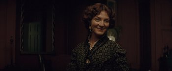 Movie still from “The Invisible Woman” (2013), directed by Ralph Fiennes – An older woman wearing a black and gold dress; Close Up shot, Low angle