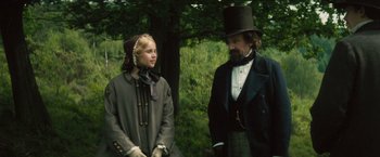 Movie still from “The Invisible Woman” (2013), directed by Ralph Fiennes – A man and a woman standing next to each other in front of a tree; Medium shot, Over the shoulder angle