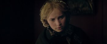 Movie still from “The Invisible Woman” (2013), directed by Ralph Fiennes – A young woman with blonde curly hair wearing a hat; Close Up shot, Over the shoulder angle