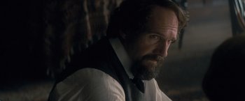 Movie still from “The Invisible Woman” (2013), directed by Ralph Fiennes – A man with a beard wearing a white shirt and a black vest; Close Up shot, Over the shoulder angle
