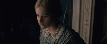 Movie still from “The Invisible Woman” (2013), directed by Ralph Fiennes – A young woman in a blue striped dress looking to her left; Close Up shot, Over the shoulder angle