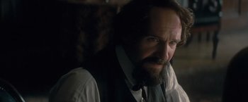 Movie still from “The Invisible Woman” (2013), directed by Ralph Fiennes – A man with long hair and a goatee is wearing a vest; Close Up shot, Over the shoulder angle