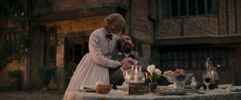 Movie still from “The Invisible Woman” (2013), directed by Ralph Fiennes – A man and a woman sitting at a dinner table; Medium shot, Low angle