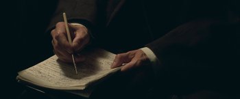 Movie still from “The Invisible Woman” (2013), directed by Ralph Fiennes – A person writing on a piece of paper; Extreme Close Up shot, High angle