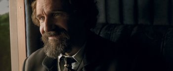 Movie still from “The Invisible Woman” (2013), directed by Ralph Fiennes – A person wearing a suit and tie; Close Up shot, Over the shoulder angle