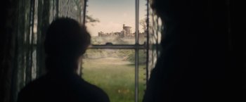 Movie still from “The Invisible Woman” (2013), directed by Ralph Fiennes – Two people looking out of a window at a castle; Wide shot, Over the shoulder angle