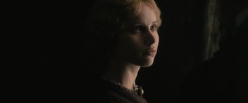Movie still from “The Invisible Woman” (2013), directed by Ralph Fiennes – A woman with blonde curly hair wearing a black dress; Close Up shot, Low angle
