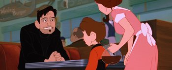 Movie still from “The Iron Giant” (1999), directed by Brad Bird – A man and a woman sitting at a table with a child; Close Up shot, Over the shoulder angle