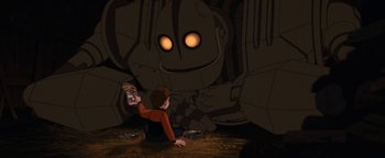 Movie still from “The Iron Giant” (1999), directed by Brad Bird – A boy sitting on the ground looking at a giant robot; Medium shot, Low angle