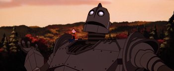 Movie still from “The Iron Giant” (1999), directed by Brad Bird – A cartoon of the iron giant and a small boy; Wide shot, Low angle
